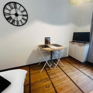 a small table and a clock on a wall at Studio Carnot - Centre - Hospices in Beaune