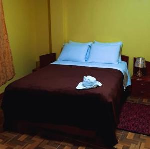 a bedroom with a bed with a towel on it at Hostal Kollarón in Chachapoyas
