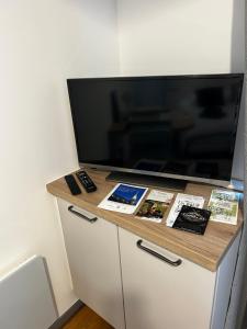 a tv on top of a dresser in a room at Le Carnot - Hospices - Centre - Climatisation in Beaune +4 photos