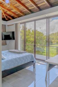 ein Schlafzimmer mit einem Bett und einem großen Fenster in der Unterkunft Cloud Forest House Monteverdes in Monteverde Costa Rica
