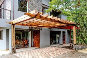 eine hölzerne Pergola an der Seite eines Hauses in der Unterkunft Cloud Forest House Monteverdes in Monteverde Costa Rica