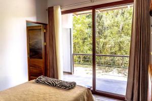 ein Schlafzimmer mit einem Bett und einem großen Fenster in der Unterkunft Cloud Forest House Monteverdes in Monteverde Costa Rica + 69 Fotos