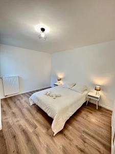 a white bedroom with a bed and two lamps at Magnificent apart Paris Bagnolet 402 with view in Bagnolet
