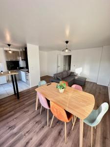 ein Wohnzimmer mit einem Tisch, Stühlen und einem Sofa in der Unterkunft Magnificent apart Paris Bagnolet 402 with view in Bagnolet