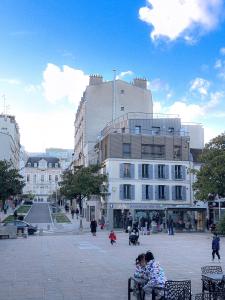 a group of people sitting on benches in front of a building at Magnificent apart Paris Bagnolet 402 with view in Bagnolet