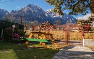 ein Picknicktisch und eine Bank mit Bergen im Hintergrund in der Unterkunft Mountain VISTA, Bușteni in Buşteni