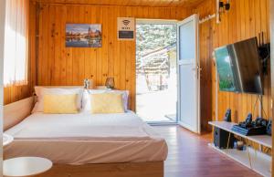- une chambre avec un lit et une porte coulissante en verre dans l'établissement Mountain VISTA, Bușteni, à Buşteni