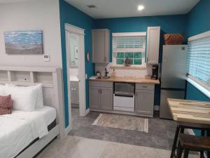 a kitchen with blue walls and a bed in a room at Studio with Private Beach on Bayou Grande in Pensacola