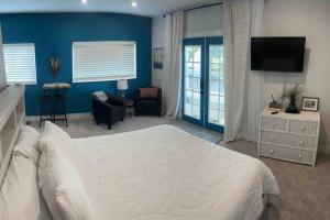 a bedroom with a white bed and a blue wall at Studio with Private Beach on Bayou Grande in Pensacola