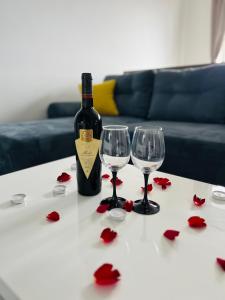 butelkę wina i dwa kieliszki wina na stole w obiekcie MONCLER RESIDENCE w Braszowie