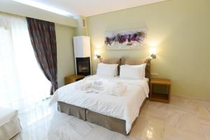 a bedroom with a large bed with towels on it at Edem Luxury Apartments in Nea Peramos