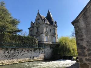 un vieux château au bord d'une rivière dans l'établissement Deux pièces terrasse, à Moret-sur-Loing
