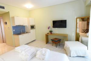 a room with two beds and a kitchen with a sink at Edem Luxury Apartments in Nea Peramos