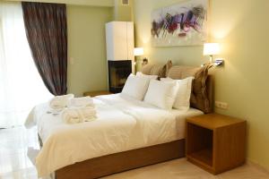 a bedroom with a large bed with towels on it at Edem Luxury Apartments in Nea Peramos