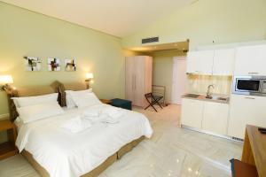 a bedroom with a large white bed with towels on it at Edem Luxury Apartments in Nea Peramos