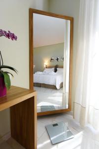 a bedroom with a bed and a large mirror at Edem Luxury Apartments in Nea Peramos