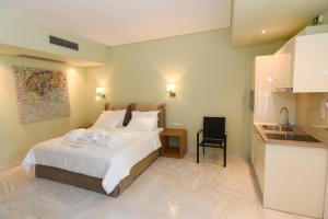 a bedroom with a large bed and a kitchen at Edem Luxury Apartments in Nea Peramos