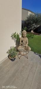 une statue d'un buddha assise sur un patio dans l'établissement Chambre Cosy non Fumeur, à Châteaurenard