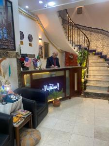 um homem sentado num bar numa sala com uma escada em AFRIC HOTEL- Casbah em Alger