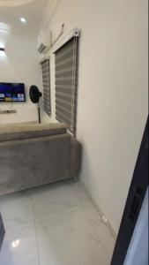 Dieses weiße Zimmer verfügt über ein Fenster und einen TV. in der Unterkunft Contemporary 1 bedroom apartment in awoyaya ibeju lekki in Awoyaya
