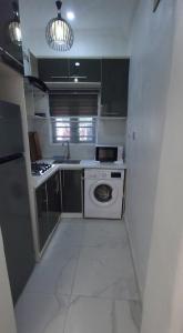 a small kitchen with a washing machine in it at Contemporary 1 bedroom apartment in awoyaya ibeju lekki in Awoyaya