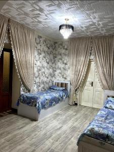 um quarto com 2 camas e um lustre em «Gulnara» Luxurious house for rent as a whole new 5 rooms and a yard. em Samarkand