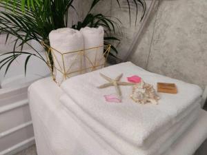 a table with towels and two starfish and a plant at Albina apartman in Eger