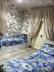 um quarto com 2 camas com lençóis azuis e brancos em «Gulnara» Luxurious house for rent as a whole new 5 rooms and a yard. em Samarkand