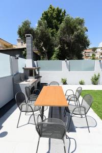 a table and chairs on a patio with a grill at Edem Luxury Apartments in Nea Peramos