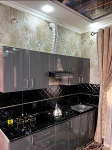 uma cozinha com uma bancada preta e um fogão em «Gulnara» Luxurious house for rent as a whole new 5 rooms and a yard. em Samarkand