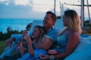 eine Gruppe von Menschen, die mit einem Baby auf einer Couch sitzen in der Unterkunft The Bannister Hotel & Yacht Club by Mint in Santa Bárbara de Samaná