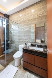 ein Bad mit einem WC, einem Waschbecken und einer Dusche in der Unterkunft THE LUXOR 5 Bedrooms Villa Vimala Hills in Gadok 1