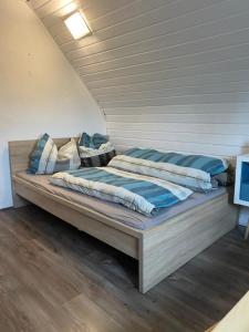 a bed with blue and white blankets and pillows on it at Kinofeeling im Reihenhaus mit schönem Garten in Schwarzenfeld