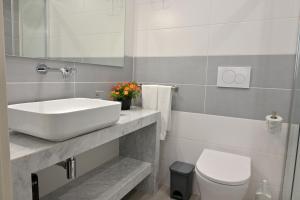 bagno bianco con lavandino e servizi igienici di Altamarea Beach Experience Villetta SE a Marina di Pescoluse
