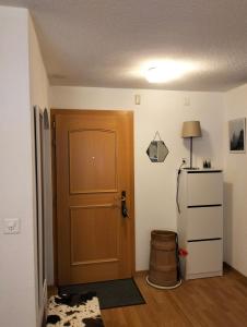 a room with a wooden door and a refrigerator at Le Sorelle Apartments 1 in Ferden