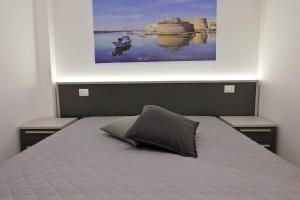 una camera da letto con un letto e un dipinto sul muro di Altamarea Beach Experience Villetta SE a Marina di Pescoluse