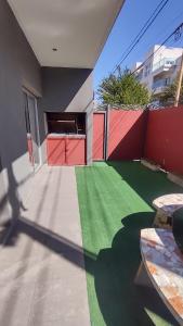 una casa con il pavimento verde e la recinzione rossa di Departamento céntrico para 4 personas -Paz en Tandil- a Tandil
