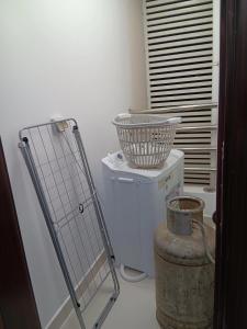 Kayan aprtment2 في مسقط: غرفة غسيل مع سلة على رأس برميل