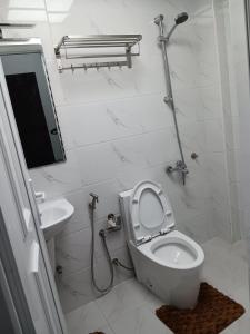 a white bathroom with a toilet and a sink at Kayan aprtment2 in Muscat