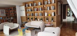 sala de estar con 2 sillas y estante para libros en Residence L´ Heritage Tennyson by BlueBay, en Ciudad de México