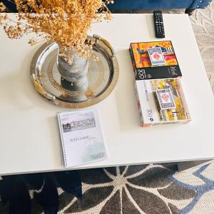 a table with a vase and magazines on it at Beautiful Nest By The Airport in Ottawa