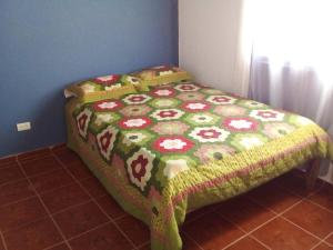 een bed in een kamer met een sprei met bloemen erop bij The Beauty of samana in Santa Bárbara de Samaná