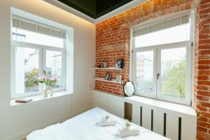 a bedroom with a brick wall and two windows at Wspólna 54a - free Parking - Apartament dla 6 osób - 450 metrów od Dworca Centralnego i Złotych Tarasów - Better Rental in Warsaw