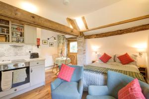 a bedroom with a bed and two chairs at Hayloft studio in historic barn in Saint Briavels