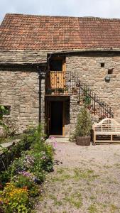 a stone building with a door and a balcony at Hayloft studio in historic barn in Saint Briavels