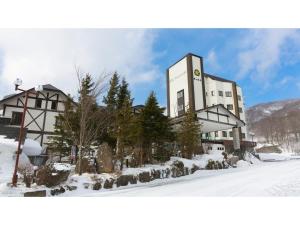 un grande edificio nella neve con alberi di fronte di Mori no RyoTei Mount Bandai - Vacation STAY 43099 a Numajiri