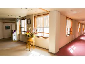 un pasillo con un jarrón de flores en un taburete en Mori no RyoTei Mount Bandai - Vacation STAY 43099 en Numajiri
