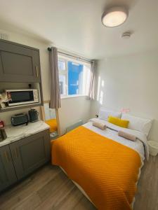a bedroom with a bed with an orange blanket at CROKE PARK STUDIO in Dublin