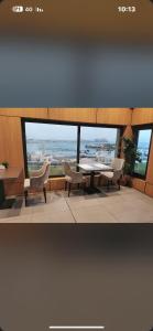فندق حور في جدة: غرفة مع طاولة وكراسي ونافذة كبيرة