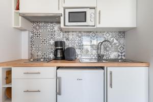 cocina con fregadero y microondas en Apartamentos Marivent, en Portocolom
